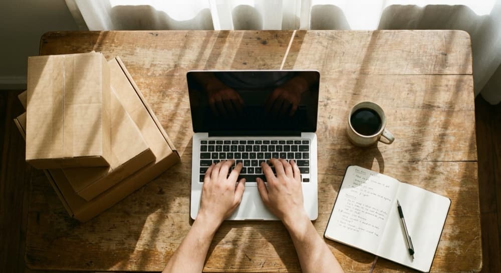 Writing a newsletter beside packed boxes
